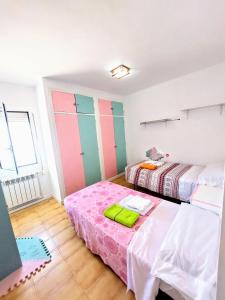 a bedroom with two beds and a pink bedvisor at CHALET CALAFAT in Calafat