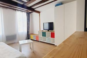 ラ・フェルテ・スー・ジュアールにあるCharmant studio coup de cœur Disneyのリビングルーム(テレビ付)、キャビネット(テーブル付)