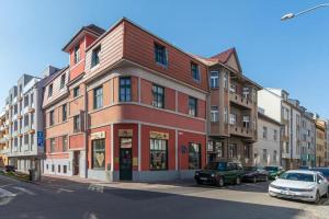 a building on a street with cars parked in front of it at Apartmán Sirius B in České Budějovice