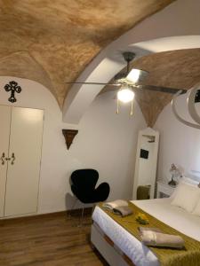 1 dormitorio con 1 cama y 1 silla negra en Flor de Lis 1, en Cáceres