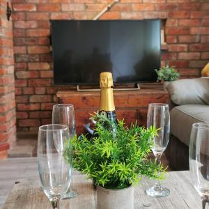 a bottle of champagne on a table with wine glasses at AnchorageWells Entire Cottage OR a King Ensuite on Room Only in Wells next the Sea