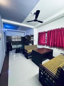 a living room with chairs and a ceiling fan at J V A Home stay Apartment Hotel in Kollam