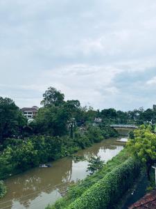 a river with trees and a bridge in the background at J V A Home stay Apartment Hotel in Kollam