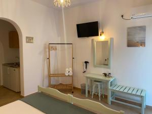 Zimmer mit einem Waschtisch, einem Tisch und einem Spiegel in der Unterkunft Ξενοδοχειο Julietta in Patitiri