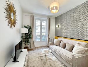 ein Wohnzimmer mit einem Sofa und einem TV in der Unterkunft 1576 - Opéra studio in Paris Olympic Games 2024 in Paris