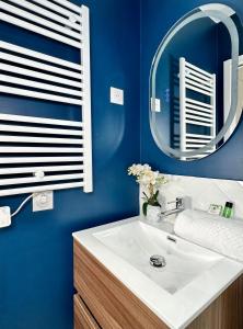 ein Badezimmer mit einem weißen Waschbecken und einem Spiegel in der Unterkunft 1576 - Opéra studio in Paris Olympic Games 2024 in Paris