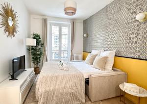 ein kleines Schlafzimmer mit einem Bett und einem TV in der Unterkunft 1576 - Opéra studio in Paris Olympic Games 2024 in Paris