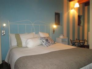 a bedroom with a large bed with white pillows at Casa Rural " El Retiro" in Laspuña