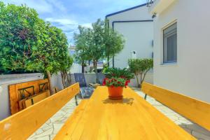 drewniany stół z doniczką na patio w obiekcie Apartment House Virić w mieście Vir +37 zdjęć