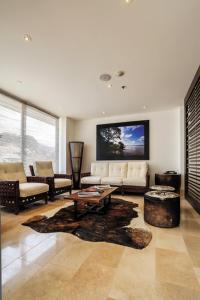 a living room with a couch and a tv on the wall at Hotel Estelar Yopal in Yopal