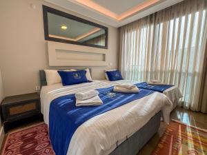 - une chambre avec un grand lit et des serviettes dans l'établissement Villa Elite, à Kusadası