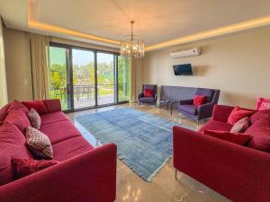 a living room with two red couches and a living room with at Villa Elite in Kusadası