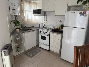 a kitchen with white appliances and a white refrigerator at LO DE LOLO Monte Grande A minutos del aeropuerto in Monte Grande