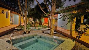 a swimming pool in front of a house with trees at Casa Alamanda - Posada Urbana in Ciudad del Este