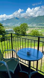einen Tisch und Stühle auf einem Balkon mit Aussicht in der Unterkunft Casa Locarnesa in Gambarogno