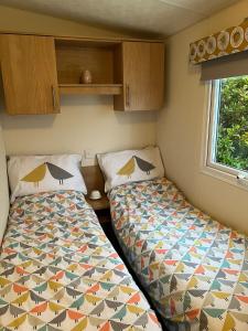 1 dormitorio con 2 camas en una habitación pequeña en Turnberry Holiday Home, en Turnberry
