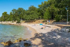 a group of people on a beach near the water at Krk Njivice in Njivice