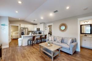 a living room with a couch and a table at Beach Cottage West in Dauphin Island