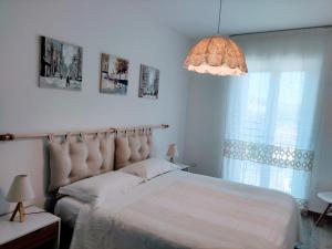 a bedroom with a large bed and a large window at La casetta al Teatro Romano in Gubbio