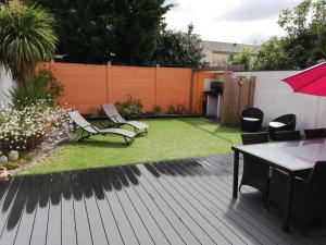 a backyard with a lawn with chairs and a table at coin de paradis 3 chambres in Fouras +5 photos