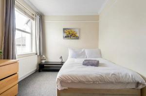 a bedroom with a large bed and a window at Lovely 3-bed 20 minutes to Central London in London