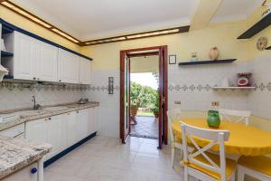a kitchen with a table and a yellow counter top at Villa Carolina - Piscina e Parco panoramico in Campagnano di Roma