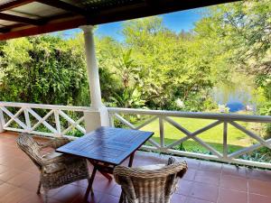 Kirkwood的住宿－Ndlovu Addo River Lodge，门廊配有桌子和两把椅子,设有围栏