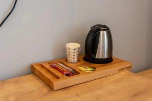 a tea kettle and a cup on a wooden table at KILIÇARSLAN OTEL in Çınarcık