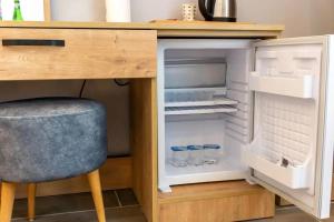 a desk with a chair and an open refrigerator at KILIÇARSLAN OTEL in Çınarcık