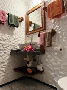 a bathroom with a sink and a mirror and towels at Hotel Entre Dos Aguas in Sámara