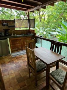 a kitchen with a wooden table and chairs on a porch at Hotel Entre Dos Aguas in Sámara