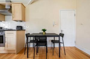 a kitchen with a table and chairs in a room at Lovely 3-bed 20 minutes to Central London in London