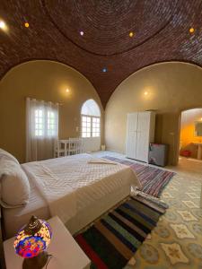 Sekhmet Retreat Centre في الأقصر: غرفة نوم كبيرة مع سرير كبير بسقف خشبي