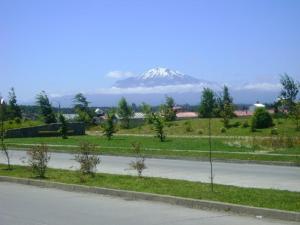 uma estrada com uma montanha coberta de neve ao fundo em Hospedaje Flover em Puerto Varas