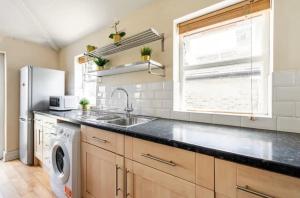 a kitchen with a sink and a dishwasher at Lovely 3-bed 20 minutes to Central London in London
