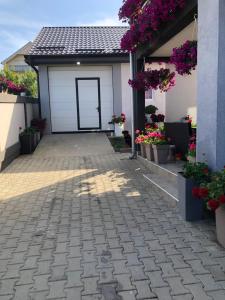 a garage with a white door and some flowers at Kristina House in Opornica