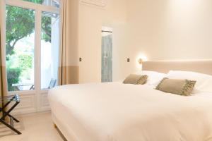 a white bed in a room with a window at La Garoupe-Gardiole in Antibes