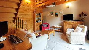 a living room with a couch and chairs and a television at Gîte chalet la Bergerie de Sentantony - Val d'Azun - Montagne Pyrénées in Bun