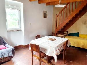 a dining room with a table and a bed at Gîtes 4 à 5 personnes in Saint-Rome-de-Tarn