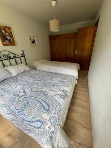 a bedroom with a bed with a blue and white quilt at Las Marmotas in Canfranc-Estación