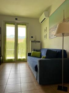 a living room with a blue couch and a glass door at Casa Manzoni in Lenno