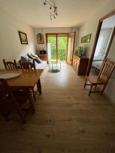 a living room with a table and chairs and a bedroom at Las Marmotas in Canfranc-Estación