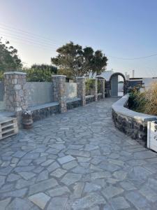 a stone walkway with a stone wall and a fence at Sklavadi Vineyard House in Kamari