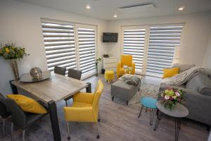 a living room with a table and yellow chairs at Seepark Cox in Goch