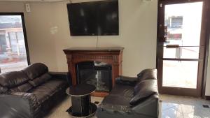 sala de estar con sofás, chimenea y TV de pantalla plana en Gurnee Motel, en Gurnee