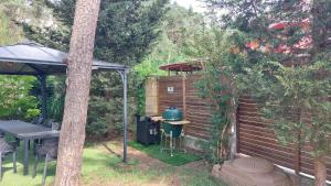 un patio trasero con una parrilla con una mesa y un árbol en Apartmány FELSENBURG Staré Splavy, en Doksy