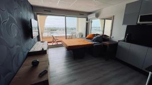 a living room with a bed and a large window at Studio, vue imprenable Marina in Le Grau-du-Roi +4 photos