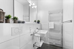 ein weißes Badezimmer mit einem Waschbecken und einem Spiegel in der Unterkunft Lieblingsplatz No 10 in Kappeln