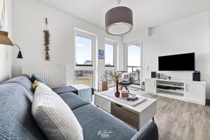 Lieblingsplatz No 10 في كابلن: غرفة معيشة مع أريكة زرقاء وتلفزيون
