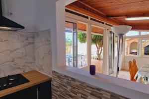 a kitchen with a view of a dining room at La Kaz Baz ' île in Étang-Salé